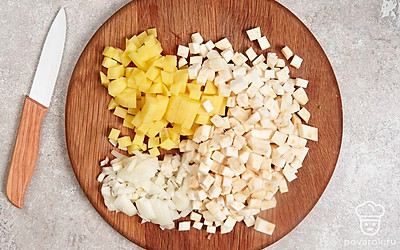 Нарежьте небольшими кубиками сельдерей и картофель. Мелко нашинкуйте репчатый и зеленый лук.