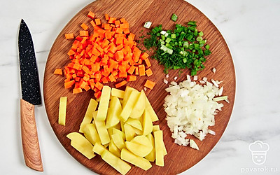 Порубите морковь кубиками, измельчите репчатый лук. Нарежьте картошку брусочками. Нашинкуйте свежую зелень. 