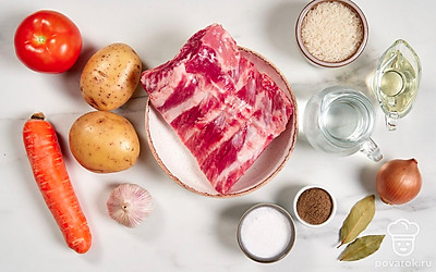 Помойте и обсушите свиные ребра. Вымойте и почистите овощи. Промойте рис под проточной водой и откиньте на сито. 