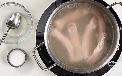 Нарежьте свиные ребра на порции, выложите их в кастрюлю. Залейте мясо водой и поставьте на огонь. Как только бульон закипит, снимите пенку и посолите его по вкусу. Варите ребра до готовности еще около получаса.