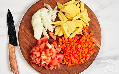 Нарубите картофель и мякоть помидора небольшими кубиками. Нашинкуйте лук перьями. Натрите морковь на средней терке. 