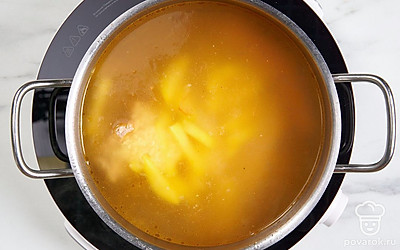 Как только мясо приготовится, положите в бульон рис и картошку. Перемешайте и продолжайте варить на среднем огне.