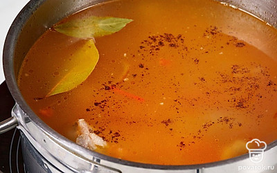 Когда картошка и рис почти приготовятся, выложите в бульон овощную зажарку. Посолите и поперчите суп по вкусу. Мелко нарежьте чеснок и отправьте его в кастрюлю. Также положите в бульон лавровый лист. Перемешайте и готовьте блюдо еще 5-7 минут.