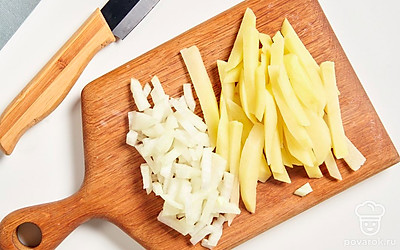 Нарежьте картофель брусочками, а репчатый лук — мелким кубиком.