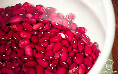 Влейте в кастрюлю воду и поставьте на огонь. С замоченной фасоли слейте жидкость. Ополосните бобовые и положите их в кастрюлю с водой, а затем доведите их до кипения и убавьте огонь на средний. 