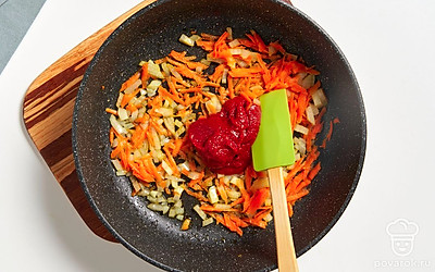 Обжарьте репчатый лук с морковью пару минут. Добавьте к зажарке томатную пасту. Перемешайте и готовьте овощи еще 3-4 минуты, а затем снимите сковороду с огня.