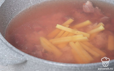 Тем временем нарежьте брусочками картофель. Положите его в кастрюлю, а затем снова доведите воду до кипения. Варите суп еще 10-15 минут.