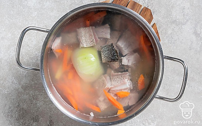 Отправьте в кастрюлю к овощам подготовленную и слегка обсохшую рыбу, но огонь при этом не выключайте. 