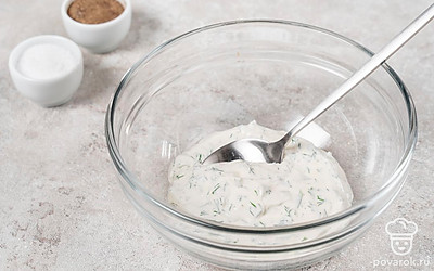 Пока кабачки запекаются, смешайте сметану и плавленый сыр. Измельчите зелень и чеснок, добавьте к начинке. Посолите, поперчите и перемешайте. 