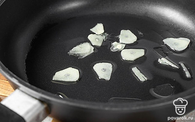 Чеснок нарежьте тонкими пластинками и добавьте в сковороду. Обжарьте его около 2-3 минут, а затем уберите.