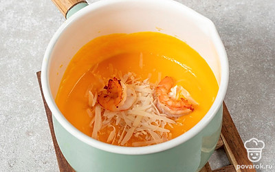 Пармезан натрите на терке и добавьте в готовый суп вместе с креветками. Хорошо перемешайте блюдо.