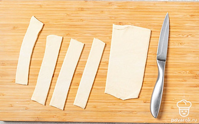 Тесто тонко раскатайте. Разрежьте его на 3 полоски, каждую полоску еще на 4 части