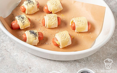 Посыпьте половину заготовок маком, другую половину — семенами кунжута. Отправьте противень в духовку на 20 минут.