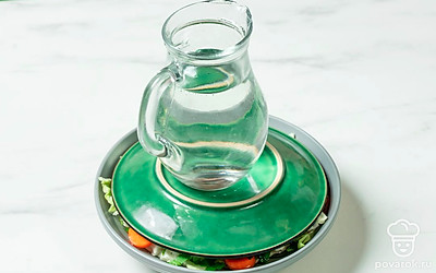 Залейте овощи маринадом. Сверху поставьте тарелку и груз. Уберите капусту в теплое место и оставьте на 5-6 часов.