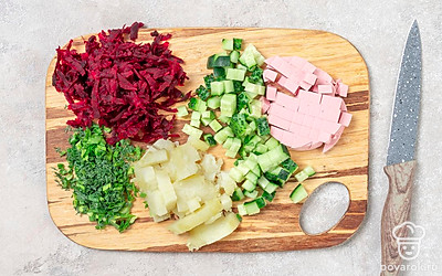 Натрите свеклу на крупной терке. Нарежьте небольшими кубиками огурец, вареную колбасу и картошку. Покрошите зеленый лук и укроп.