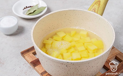 Картофель нарежьте кубиками и выложите в кастрюлю с водой. Оставьте вариться на среднем огне. 