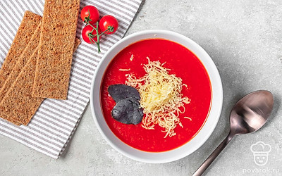 Томатный суп-пюре из запечённых овощей разлейте по порционным тарелкам, присыпьте сырной стружкой, подайте с чесночными или сырными гренками.