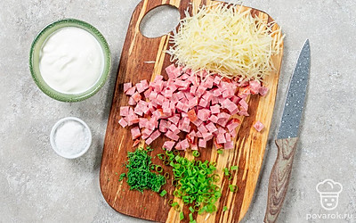 Укроп и лук мелко порубите. Колбасу нарежьте маленькими кусочками. Сыр натрите на терке. Переложите ингредиенты в миску, добавьте сметану и соль. Хорошо перемешайте.