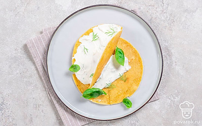 Веточки зелени мелко порубите и смешайте с творожным сыром. Намажьте смесью готовые лепешки, сложите их пополам и подайте на стол в качестве закуски к основному блюду.