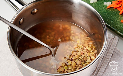 Займитесь чечевицей. Промытую чечевицу засыпьте в кастрюлю, влейте литр воды. Доведите до кипения, снимите пену, снизьте огонь до умеренно-тихого, влейте стакан воды. Варите 30 минут.