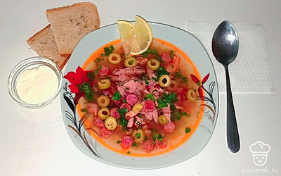 Подавайте солянку разлив по порционным тарелкам. Украсьте зеленью, нарезанными оливками и ломтиком лимона. В пиале подайте свежую сметану.