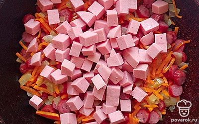 Лук нарежьте мелкими кубиками, морковь нарежьте тонкой соломкой и отправьте на разогретую сковороду с растительным маслом на 3 минуты. Охотничьи колбаски и вареную колбасу нарежьте кружочками и отправить к зажарке еще на 5 минут.