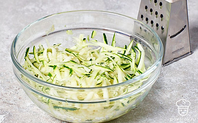 Натрите кабачки на крупной терке, а затем хорошенько отожмите жидкость.