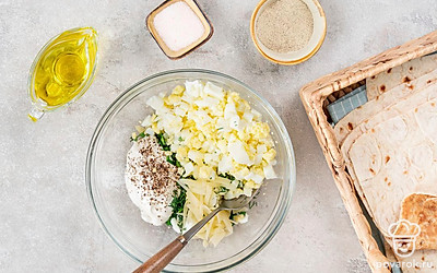 4 яйца отварите вкрутую, очистите и измельчите. Поставьте разогреваться духовку до 190 градусов. Порубите лук, укроп и петрушку. Сыр натрите на терке. Все смешайте, добавьте сметану, соль и перец. Перемешайте начинку. 