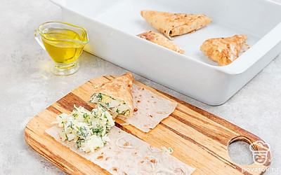 Разрежьте лаваш на 6 одинаковых частей. Выложите на каждый пласт начинку и сверните конвертом, чтобы начинка не выпала. Выложите на противень, смажьте оставшимся сырым яйцом. Отправьте в духовку на 20 минут.