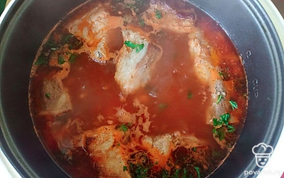 Когда ребра сварятся до полуготовности, добавьте нарезанный кубиками картофель. Когда картофель почти сварится, нужно добавьть в кастрюлю томатную заправку, рис и зелень. Варите 15 минут.