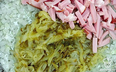 Подготовленный лук порежьте мелкими кубиками. Сковороду разогрейте на огне, налейте подсолнечное масло. Выложите лук и обжарьте в течение 3 минут. Огурцы натрите на крупной терке. Ветчину порежьте тонкой соломкой. Добавьте ветчину и огурцы в сковороду с луком. Периодически помешивая, жарьте в течение 5 минут. Добавьте томатную пасту и жарьте еще 5 минут на небольшом огне. Охотничьи колбаски порежьте кружочками толщиной 1 см и также добавьте в сковороду. Жарьте на небольшом огне еще 5 минут.