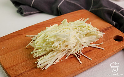 Нашинкуйте капусту тонкими полосками.