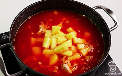 В большую кастрюлю переложите тушеные в томатной пасте морковь, лук и капусту. Влейте куриный бульон и томатный сок. Добавьте порезанный картофель и кусочки курицы. Всыпьте рис. Варите капустняк до готовности картофеля и риса.