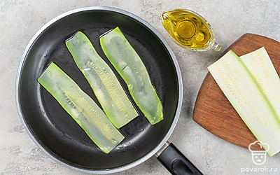 Нарежьте кабачки тонкими слайсами и обжарьте на сковороде с обеих сторон до золотистости.