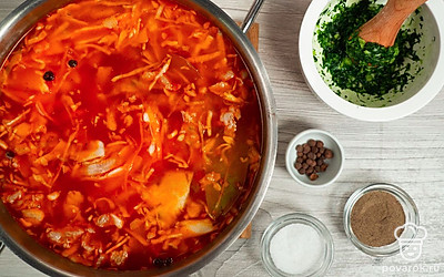 Сварите щи. Кастрюлю с мясом достаньте из духовки, добавьте к нему картофель и квашеную капусту. Затем добавьте зажарку, посолите и поперчите по вкусу. В смесь положите лавровые листы и душистый перец. Поставьте кастрюлю обратно в духовку и оставьте на 3 часа. Затем добавьте смесь из зелени и чеснока, хорошо перемешайте. Готовые щи накройте крышкой, заверните в полотенце и дайте им настояться 30 минут.