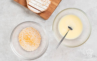 Яйцо взболтайте. На отдельном блюдце смешайте сухари и кунжут. Сыр порежьте пластинками толщиной около 1 см. 