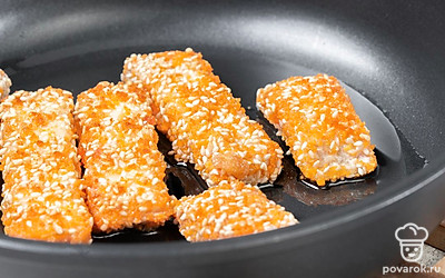 Ломтики сыра обмакивайте в яйцо, следом тщательно обваливайте в панировке. Переложите на сковороду с горясим маслом. Обжарьте на сильном огне с обеих сторон до золотистой корочки. 