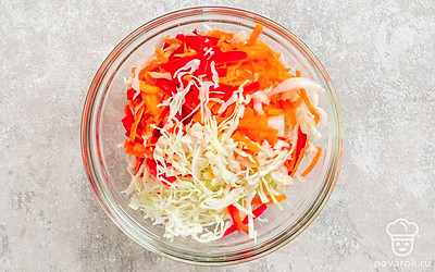 Нарежьте перцы соломкой. Натрите морковь на крупной терке. Нашинкуйте капусту тонкими полосками. Мелко порубите чеснок ножом или пропустите через пресс. Выложите овощи в миску. Хорошо перемешайте. 