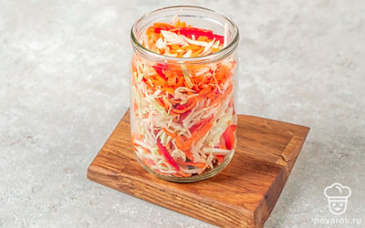 Плотно заполните простерилизованную банку капустой с овощами. Оставьте от края горлышка примерно 1 см. 