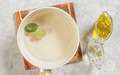 Налейте в кастрюлю воду, всыпьте соль и сахар, добавьте лавровый лист. Поставьте на огонь и доведите до кипения. Влейте подсолнечное масло. Дайте закипеть повторно и выключите огонь. Влейте уксус и уберите с плиты. 