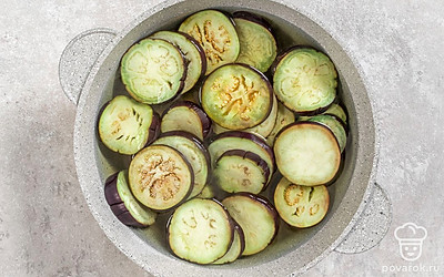 Нарежьте баклажаны крупными кружочками. Натейте в кастрюлю 800 мл воды, поставьте на огонь и оставьте до кипения. Положите в кипящую воду нарезанные баклажаны. Варите 10 минут.