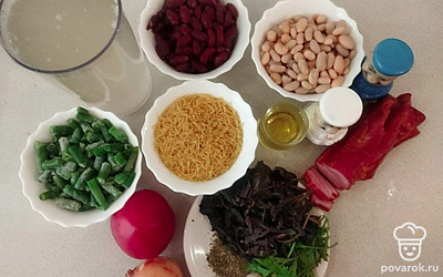 Подготовьте продукты для минестроне. Очистите лук и чеснок и помойте их. Зелень помойте и обсушите. Сварите бульон на свинине с косточкой. Фасоль отдельно замочите на несколько часов и отдельно сварите почти до готовности. Белую сварите в мясном бульоне.