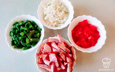 Острым концом ножа сделайте на томатах крестообразные надрезы и опустите их в кипяток. Затем окуните их в холодную воду и снимите кожицу. Разрежьте томаты пополам, очистите от семян, мякоть нарежьте на кусочки. Грудинку нарежьте ломтиками. Лук измельчите.