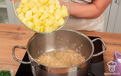 Приготовьте овощи. В глубокой кастрюле с толстым дном обжарьте лук на смеси сливочного и растительного масла в течение 3-5 минут, не забывайте перемешивать. Затем добавьте картофель, немного прогрейте, приблизительно 2-3 минуты. Перемешайте.