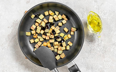 Нарежьте баклажан небольшими кубиками. Разогрейте на сковороде растительное масло. Обжарьте баклажан до золотистой корочки на сильном огне в течение 5-6 минут, регулярно помешивая.