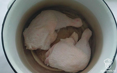 Поставьте кастрюлю с водой на средний огонь, поместите туда помытые окорочки. Посолите по вкусу и доведите до кипения, снимите пену и варите еще 30 минут. Выньте вареное мясо и разделите его на маленькие кусочки. Зелень мелко измельчите, а чеснок раздавите.