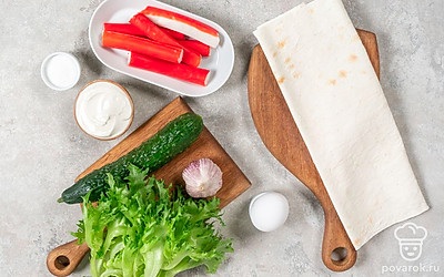 Очистите чеснок от шелухи. Помойте огурец. Промойте и обсушите салат. Очистите крабовые палочки от пленки.