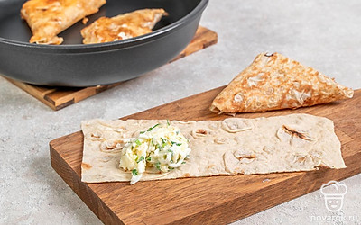 Разрежьте лаваш на небольшие прямоугольники. В центр каждого прямоугольника выложите немного начинки. После этого сверните лаваш конвертиком. Поставьте сковороду на огонь и влейте в нее растительное масло. Выложите готовую закуску и обжарьте ее по 5 минут с каждой стороны.