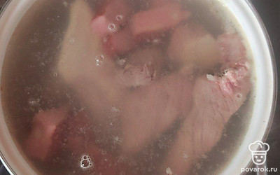 В большую кастрюлю налейте 3 л воды и поставьте варить кость. Доведите до кипения, а затем загрузите грудинку и нарезанные свиные ребрышки. Соберите пену, добавьте лавровый лист и перец горошком. Варите бульон под закрытой крышкой на медленном огне 2 часа, до мягкого состояния мяса. Затем извлеките кость и ребра из бульона, удалите кости, а мясо нарежьте мелкими кусочками.