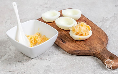 Натрите сыр и чеснок на мелкой терке, смешайте с чесноком. Добавьте майонез и соль. Наполните яичные белки этой смесью.